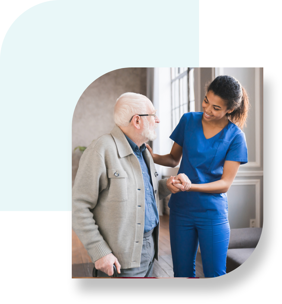 A nurse talking to an older man in blue scrubs.