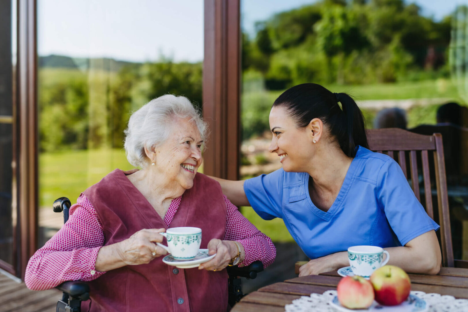 A woman and an old lady sitting at a table