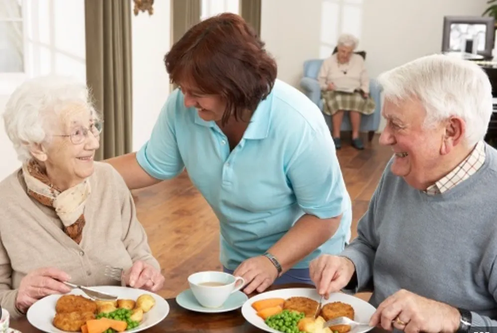 A group of people sitting at a table with plates.