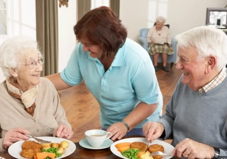 A group of people sitting at a table with plates.